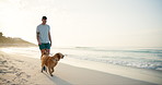 Beach, travel and man with dog, walking and vacation with happiness, bonding together and game. Ocean, seaside and person with pet, golden retriever and summer holiday with nature, wellness or energy