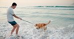 Beach, travel and man with dog, waves and vacation with happiness, bonding together and game. Ocean, seaside and person with pet, golden retriever or summer holiday with nature, wellness or coastline