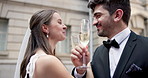 City, kiss and couple at wedding with champagne, glass and happy bride with groom in street together. Urban romance, man and woman with court marriage, love and drinks for outdoor celebration in town