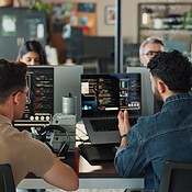 Office, man and training on computer for coding with teamwork and ...