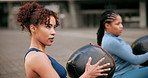 Outdoor, workout and women in city with medicine ball, arm muscle and wellness on ground. Weight training, friends and athlete with fitness, exercise and rest with balance, sport and downtown