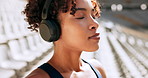 Woman, runner or breathing with headphones at stadium for race, sprint or workout preparation. Young, female person or serious athlete with music for stretching, exercise or getting ready for fitness