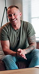 Therapy, happy and man on sofa at consultation for trauma, help and mental health conversation. Psychology, smile and person talking in counseling office for advice, self care and wellness support.