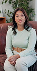 Therapy, conversation and Asian woman on sofa at consultation for trauma, help and mental health. Psychology, anxiety and female person talking in counseling office for advice, self care and support.