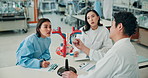 Doctor, students and learning with model heart, advice or teaching with arteries, anatomy and healthcare. Japanese people, cardiology and education for group, writing and listening at medical college