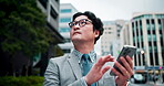 Japanese, businessman and check with smartphone in city, market research or property inspection for realtor. Urban, male person or real estate agent with digital for online listing or site assessment