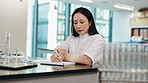 Science, education and woman writing notes, thinking or studying at Japanese medical college. Laboratory, test tube and university student in class with notebook, pen and research ideas for exam.
