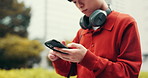 Japanese, hands and man with headphones, cellphone and internet with social media, texting and relax. Asian person, outdoor and guy with smartphone, digital app and message to contact and connection