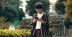 Asian man, student or walking with headphones for music, listening or radio podcast in city. Young, male person or travel with mobile smartphone for entertainment or social media in town or Japan