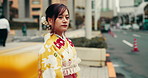Woman, traditional dress and waiting for taxi in city for traveling or transport to cultural event in Japan. Female person, outdoor and confident downtown in kimono for fashion, style and fabric