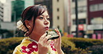 Japanese woman, food and eating with traditional clothes, outdoor and fashion as model or creative. Female person, diet and dress in style, culture or nutrition for travel, taste or adventure in city