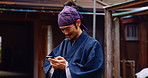 Japan, man and smile with phone in city with social media, texting and internet scroll outdoor. Kimono, fashion and Japanese culture with mobile networking, contact and traditional montsuki on web