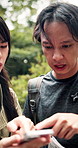Confused, hiking and couple with smartphone, forest and searching for location, lost or discussion. Outdoor, unsure and mobile for navigation app, doubt and browsing for directions or people in Japan