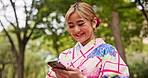 Nature, japanese woman and smartphone with typing a text message, online networking and scroll social media. Travel, smile or person in kimono fashion with phone for reading notification or download