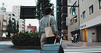 Woman, travel and back in city with luggage, direction and suitcase for vacation on urban crosswalk. Person, tourist and holiday with baggage, location and commute to hotel on metro street in Japan
