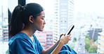 Nurse, woman and stress with phone by hospital window for bad news, medical results fail and disappointed. Medicine, Japanese person and frustrated with smartphone for negative clinic review or email