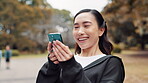 Asian woman, phone and athlete laugh in nature, funny message and runner break in park. Female person, relax and online app for conversation humor, fitness and reading joke on social media in Japan