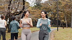 Japanese, running and women in park, fitness and wellness with energy, practice and exercise. Healthy people, friends and runners in city, cardio or workout with morning routine, nature and training
