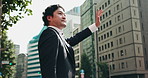 Business man, city and wave for taxi, travel and outdoor with low angle for trip, journey or ride in street. Person, hand and sign for driver, chauffeur or waiting for transportation on road in Japan