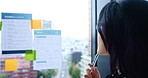 Japanese, business woman and thinking with glass wall, window and sticky note for brainstorming. Female person, planning and idea for project management, deadline or research as team leader in office