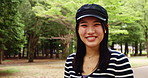 Face, outdoor and Japanese woman with hat, smile and confidence with trees, happiness and calm. Portrait, Asian person and girl with stylish clothes, summer holiday and pride with wellness in park