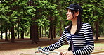 Relax, bike and thinking with Japanese woman in park for travel, carbon footprint and walking. Reflection, transportation and peace with asian person and bicycle in nature for cycling and wellness