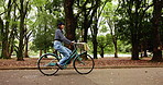 Japanese woman, bicycle and travel outdoor at park for health, wellness or trip. Bike ride, cycling or happy female person at garden for journey, commute or exercise on transport for carbon footprint