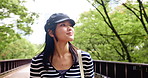 Japanese woman, travel and walking at park outdoor for dream holiday, vacation and sightseeing trip. View, thinking and female person at garden for journey, commute and tourist on road or bridge