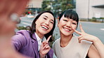 Selfie, girl friends and city with Japanese women, peace sign and social media with smile outdoor. Internet, happy and holiday with young professional on morning commute in Tokyo with fun bonding