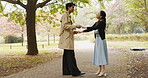 Japanese couple, holding hands and outdoor for bonding, relationship and love in park or countryside. Woman, man and happy for romance, connection and conversation with dancing on valentines day date