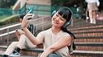 Japanese woman, selfie and smile with headphones, steps and outdoor for web blog and communication. Girl, happy influencer and phone for photography, profile picture or memory on social media