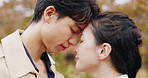 Japanese couple, forehead touch and happy in park or countryside for bonding, relationship and love. Woman, man and outdoor for romance, connection and commitment with eyes closed on valentines day