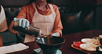 Hands, Japanese woman and soy sauce for healthy meal, food and traditional cuisine with bowl. Female person, serving and dinner as culinary culture, diet or preparing dish in Asian restaurant or cafe