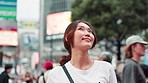Happy, asian woman and thinking with city in Japan for sightseeing, adventure or travel. Japanese, female person or tourist with smile or wonder for destination, dream or location in an urban town