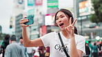 Happy, asian woman and selfie with emoji in city for photography, memory or picture in Tokyo. Japanese, female person or vlog with smile or peace sign for capture, moment or travel in an urban town
