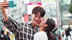 Happy, asian couple and selfie with kiss in city for memory or picture together in Tokyo. Japanese, man and woman with smile, affection or love for photography or moment in an urban town of Japan