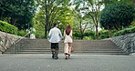 Couple, running and holding hands in park for bonding, love or connection with romance, back or support. Man, woman and adventure outdoor for relationship, travel or tourism with fun holiday in Japan