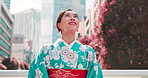 Woman, kimono and travel in city with smile, thinking and outdoor with search, street or location. Person, happy and reflection with traditional clothes, memory and culture on urban sidewalk in Japan