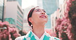 Woman, kimono and happy for travel in city, thinking and search for direction, street or location. Person, smile and reflection with traditional clothes, memory and culture on urban sidewalk in Japan