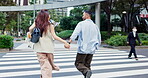 Couple, back and holding hands with crosswalk in city, street and excited for travel and vacation or care. Man, Japanese woman and together with adventure, support and love on holiday in Tokyo