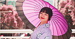 Woman, kimono and face with umbrella of Japan, outdoor bridge and travel to city for view. Female person, traditional clothes and portrait in town for culture, local fashion and exploring urban