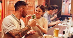 Night, couple and travel in Japan with street food, traditional snack and shishito for eating. Happy woman, man and green pepper at Tokyo bazaar to experience culture, tourism and indigenous cuisine