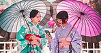Phone, umbrella and kimono with Japanese friends for traditional festival, social media and conversation. Happy women, mobile and culture with funny joke, gossip and cherry blossom for communication