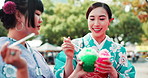 People, outdoor and eating dessert at Japan festival with sharing slush drink, taste test and enjoyment in kimono. Traditional fashion, women and friends with kakigori ice for refreshment and culture