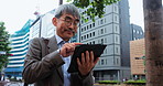 City, walking and mature businessman with tablet, online chat and salaryman on morning commute. Urban, street and Japanese business man typing on digital app for communication, schedule or planning