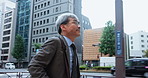 Mature, asian man and running with bag in city to work for business trip, rush or job opportunity. Businessman, employee or late on sidewalk, pavement or street for career, commute or travel in Japan
