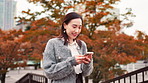 City, park and happy woman with phone, walking and communication on morning commute with smile. Smartphone, search and girl on outdoor adventure with mobile app, social media or urban travel in Japan