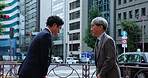 Japanese, businessmen or meeting with bow for greeting, conversation or introduction in city. Asian men, employee or colleagues talking with respect for business tradition on street sidewalk in Japan