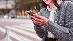 Hands, typing and woman in city with phone, connection and happy online chat on morning commute. Smartphone, search and girl in street with mobile app for social media post with urban travel in Japan