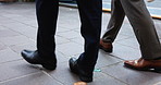 Sidewalk, shoes and business people with walking, for travel, commute and journey to workplace. Closeup, corporate employees and legs in morning for movement, location and carbon footprint in Japan